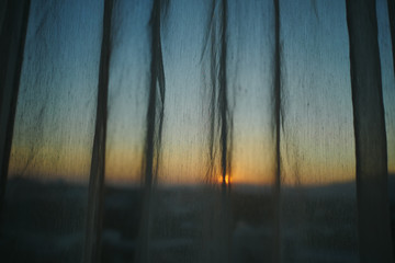 sunlight through white curtain with sunset sky view outside the window