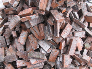 Stack of broken red bricks on the ground, old bricks texture background