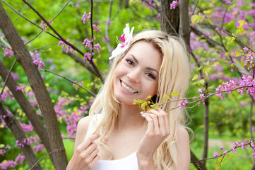 Fototapeta premium Smiling woman portrait in blossom park