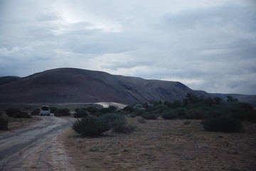 Off-road trip, dramatic sky in the background. Misty road in the mountains