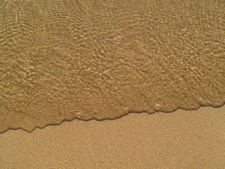 Fototapeta na wymiar Transparent sea wave on the sand