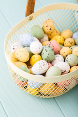 Metal basket with colourful Easter quail eggs