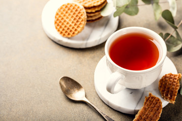 Cup of tea with syrupwaffles cookies