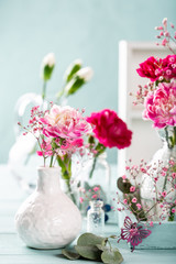 Bouquet of pink carnation on light turquoise wooden background