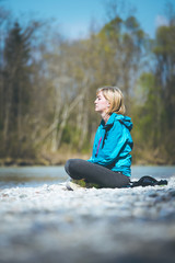 Meditation and relaxation: Woman is meditating outdoors on a pebble beach. Enjoying the summer.