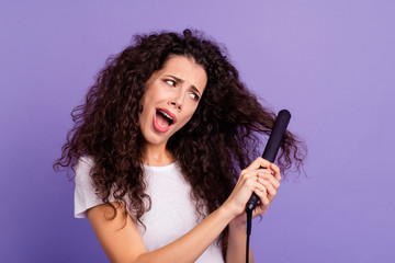 Close-up portrait of nice cute lovely attractive confused wavy-haired lady using new electric product hot high temperature ironer isolated on bright vivid shine violet pastel background
