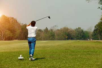 Blurred golfer playing golf in the evening golf course, on sun set evening time.