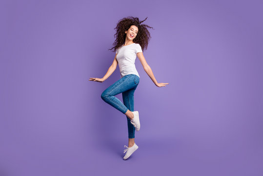 Full length side profile body size photo funky beautiful she her lady jump high spread hands arms cheerleader wear casual jeans denim white t-shirt sneakers isolated purple violet bright background