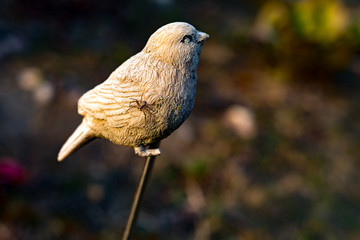 Small plastic sparrow with a spider on his wing