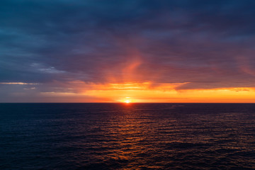 Cloudy sunrise view over the ocean horizon.