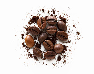coffee beans and scattered milled coffee on white background