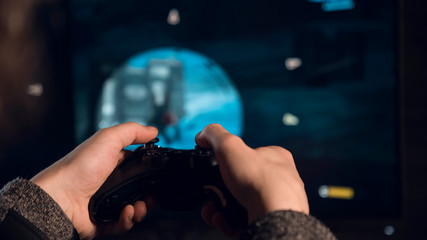 Close up on the Gamepad in the hands in front of screen © Digitalbarn