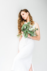 elegant girl in dress holding bouquet of flowers on white