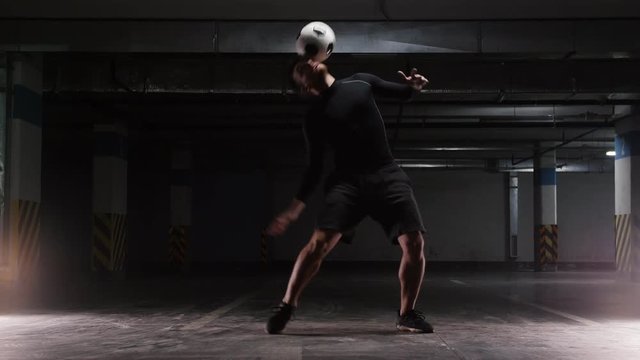 A young soccer man training tricks with the ball. Rolling the ball from the neck to the chest
