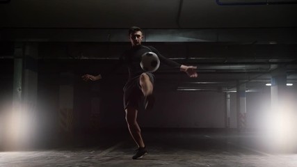 A young soccer man training tricks with the ball. Jumping above the ball