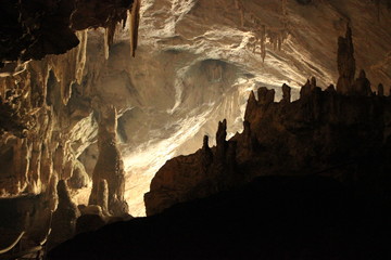 wide angle panoramic view showing the opening of a cave, Thum Lod cave, Bang Ma Pha, in Northern Thailand. Touristed cave with stalagmites and stalactites and a river running thru it.