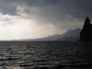 Fototapeta na wymiar The sea and the sky before the rain with the ship in the background. The Black Sea. The Crimea. Karadagh