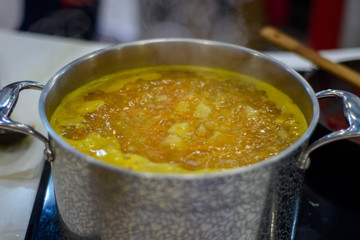 vegetable soup is brewed in a large saucepan on the stove