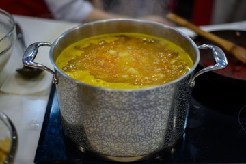 vegetable soup is brewed in a large saucepan on the stove