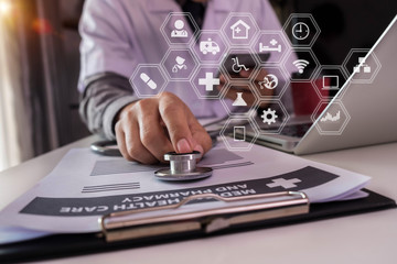 Male doctor working on desk with laptop computer and paperwork in the office. Medical and doctor concept