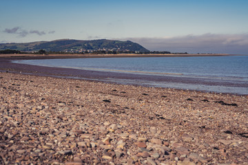 The beach in Blue Anchor, Somerset, England, UK - looking at the Bristol channel and Minehead in the background