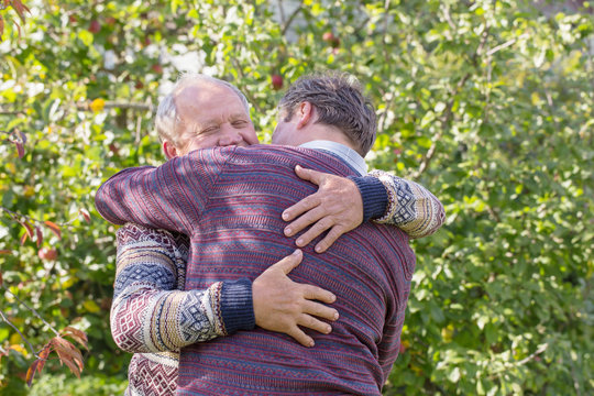 two men hugging in autumn park