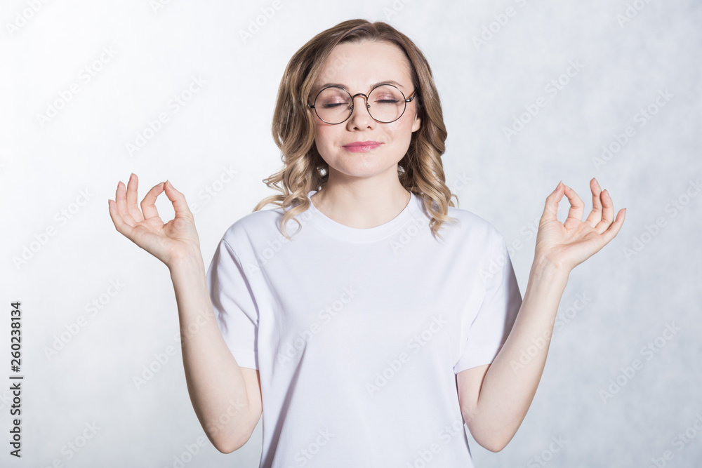 Wall mural handsome young woman in glasses shows ok sign. body language concept.