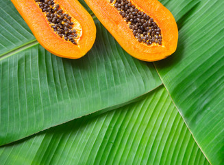 Top view of fresh half papaya on banana leaves, exotic tropical fruit, copy space, summer background
