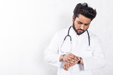 Fototapeta premium Handsome young doctor in a white coat with a stethoscope. Health care concept.