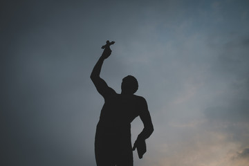 Fototapeta na wymiar Statue of a man with cross