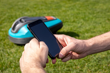 Handy neben Roboterrasenmäher, Digitalisierung, Smart Home