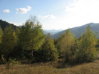 Obraz premium Mountain landscape with blue sky. View of the mountains and green hills from above.