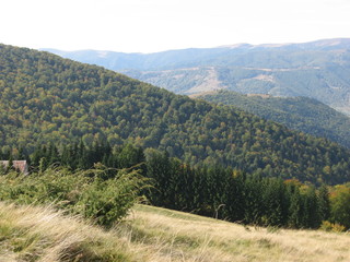 Naklejka premium Mountain landscape with blue sky. View of the mountains and green hills from above.