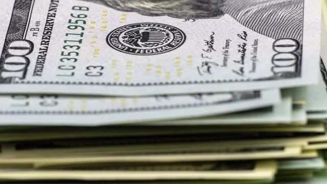 Spending money concept. Bundle of American dollars is decreasing one by one bill, becoming smaller and smaller. Stop motion animation.