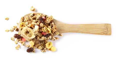 Crunchy tropical muesli pile mix with banana, pineapple, papaya slices and raisins with wooden spoon isolated on white background