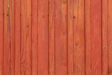 Painted red old wooden fence with old nails in planks. Red bright wood abstract background. Horizontal color photography.
