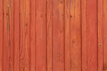 Painted red old wooden fence with old nails in planks. Red bright wood abstract background. Horizontal color photography.