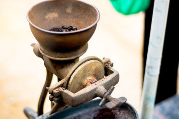 Grinding coffee by hand by an ancient grinder. 