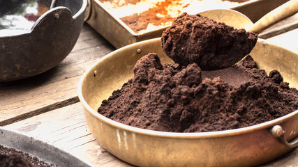 Coffee powder that has been crushed Put in a brass container And having a spoon to scoop it up.