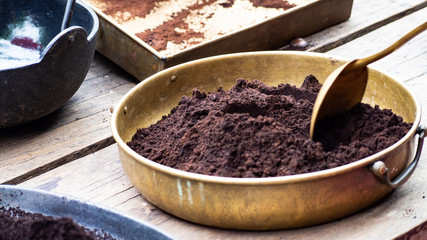 Coffee powder that has been crushed Put in a brass container And having a spoon to scoop it up.