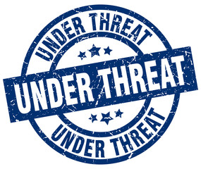 under threat blue round grunge stamp