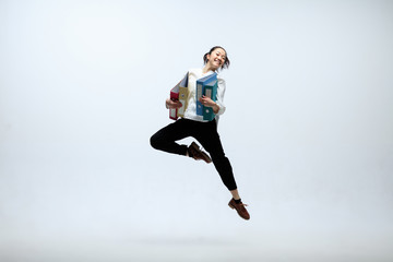 Winged by new deals. Happy woman working at office, jumping and dancing in casual clothes or suit...