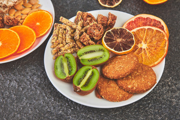 Healthy snacks -  variety oat granola bar,  rice crips, almond,  kiwi, dried orange