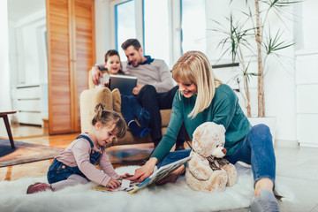 Happy family having fun on floor of in living room at home, laughing.