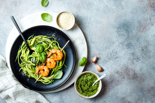 Zucchini spaghetti with pesto sauce and grilled shrimp skewers. Vegetarian vegetable low carb pasta. Zucchini noodles or zoodles.