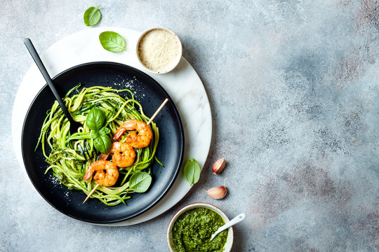 Zucchini spaghetti with pesto sauce and grilled shrimp skewers. Vegetarian vegetable low carb pasta. Zucchini noodles or zoodles.