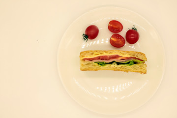 Sandwich with ham, cheese, tomatoes, lettuce, and crispy bread. Above view isolated on white background
