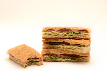 Sandwich with ham, cheese, tomatoes, lettuce, and crispy bread. Above view isolated on white background