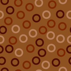 Rings - seamless pattern. Beige and brown circles fill the space and touch each other, mustard background. For fabric, clothing, paper, wrappers, surfaces, background, etc.