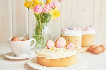 Easter cake with gingerbread on the table, the table is decorated with flowers, macaroons  and eggs